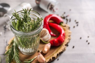 Ahşap tahta üzerinde taze biberiye ile jar