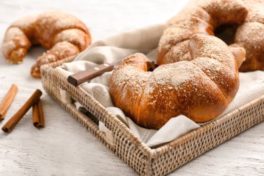 Beyaz tahta masada hasır tepsi ile lezzetli taze hilal rulolar