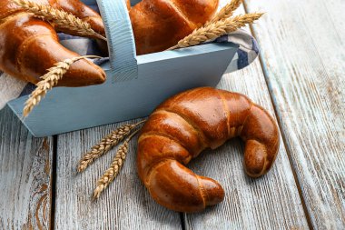 Sepet ve lezzetli taze hilal rulolar ve buğday spikelets ahşap tablo