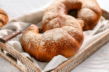 Beyaz tahta masada hasır tepsi ile lezzetli taze hilal rulolar