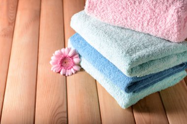 Ahşap masa çiçek ile temiz yumuşak havlu yığını