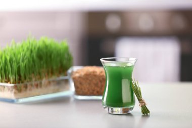 Bardak taze buğday çimen suyu masada