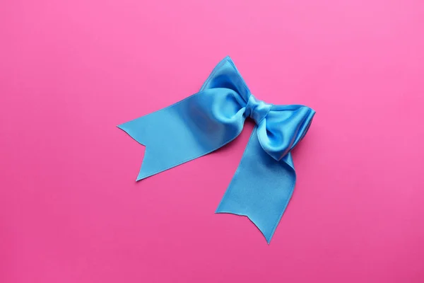 美しい色の背景上のブルーのリボンの弓 — ストック写真