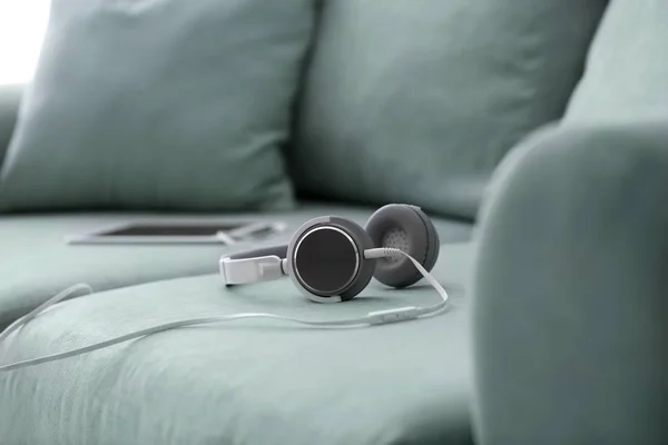 Headphones with tablet PC on sofa