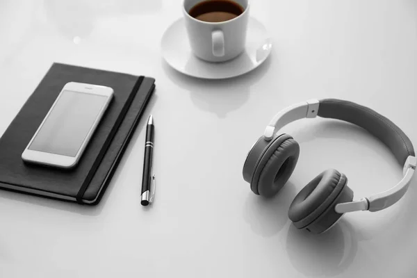 Auriculares Con Teléfono Móvil Taza Café Sobre Mesa Blanca —  Fotos de Stock