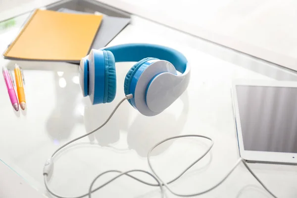 Kopfhörer Mit Tablet Und Schreibwaren Auf Glastisch — Stockfoto