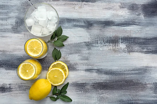 Limon dilimleri ve ahşap masa buz küpleri ile gözlük