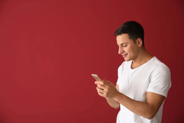 Junger Mann Mit Handy Auf Farbigem Hintergrund — Stockfoto