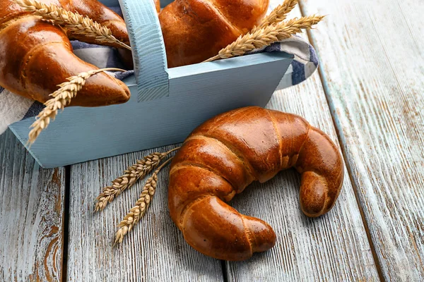 Sepet ve lezzetli taze hilal rulolar ve buğday spikelets ahşap tablo