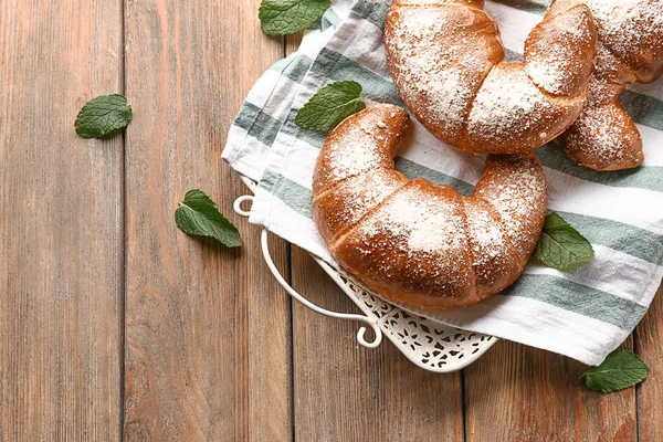 Lezzetli taze hilal ile tepsi ahşap masa üzerinde rulo