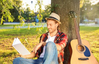 Yakışıklı delikanlı Park'ta dinlenme kitap ile