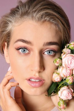 Çıplak makyaj ve renk arka plan, closeup üzerinde çiçekler olan güzel kadın