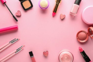 Dekoratif kozmetik ve renk arka plan üzerinde küçük kalpler çerçeve yaptı