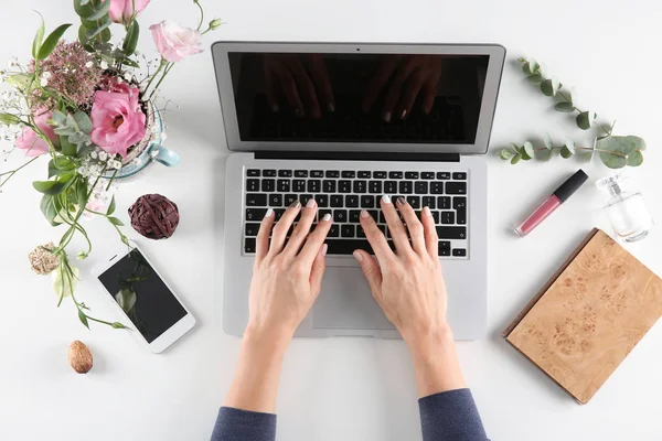 Woman using laptop on white table