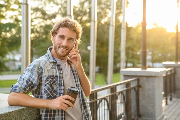 Cep Telefonu Park Konuşurken Kahve Ile Yakışıklı Genç — Stok fotoğraf