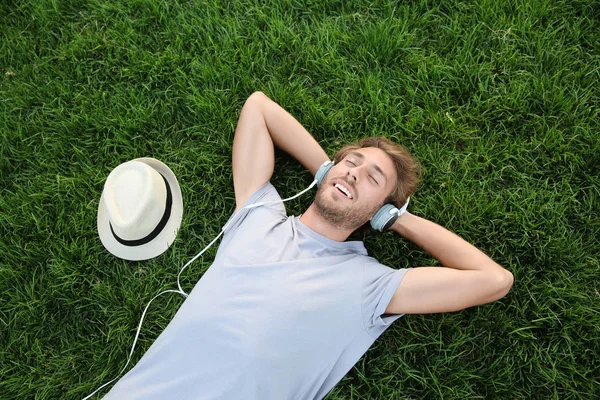 Joven Guapo Escuchando Música Sobre Hierba Verde Parque —  Fotos de Stock