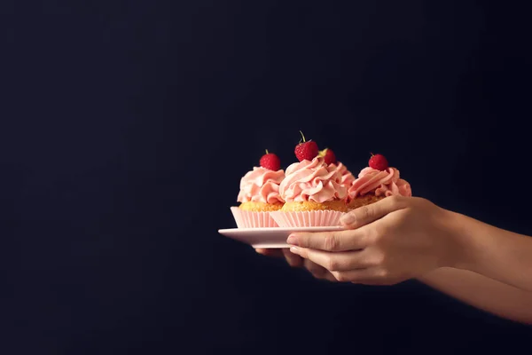 Main Féminine Tenant Plaque Avec Délicieux Cupcakes Sur Fond Sombre — Photo