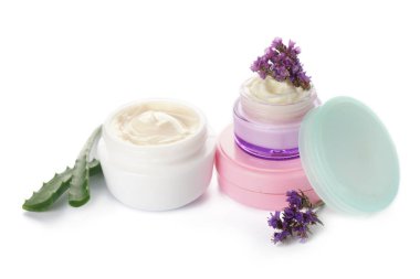 Aloe vera ve çiçeklerle beyaz arka plan üzerinde vücut kremi kavanoz