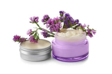 Vücut kremi ve çiçeklerle beyaz zemin üzerine kavanoz