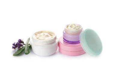 Aloe vera ve çiçeklerle beyaz arka plan üzerinde vücut kremi kavanoz