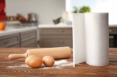 Rulo kağıt havlu yumurta, un ve oklava ile mutfak masasında