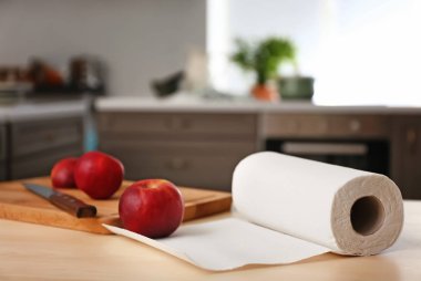 Rulo kağıt havlu ile elma ve kesme tahtası mutfak masasında