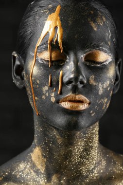 Siyah ve altın boya koyu arka plan, closeup karşı vücudu üzerinde güzel bir kadınla