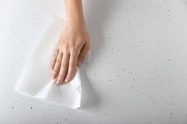 Kağıt havlu ile masa lambası silerek kadın