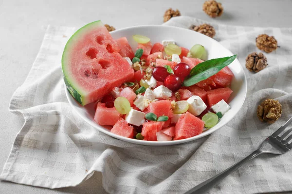Plate with delicious watermelon salad on table