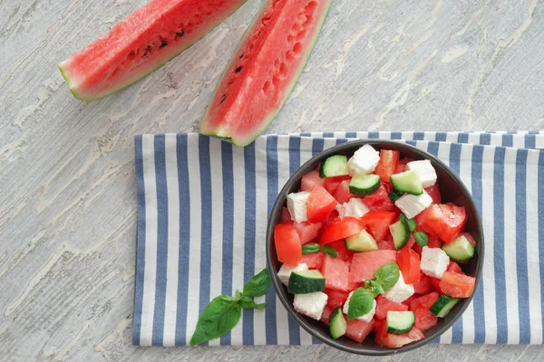 Bowl with delicious watermelon salad on light table