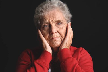 Koyu arka plan üzerinde depresif yaşlı kadın