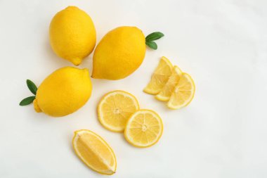 Beyaz arka planda olgun sulu limonlarla düz kompozisyon