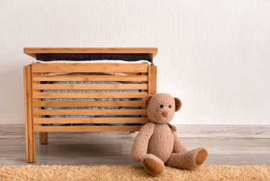 Ahşap Çamaşırhane kutusuyla havlu ve oyuncak ayı beyaz duvarının yakınında katta