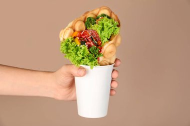 Fincan lezzetli kabarcık gözleme renk arka plan üzerinde tutan kadın