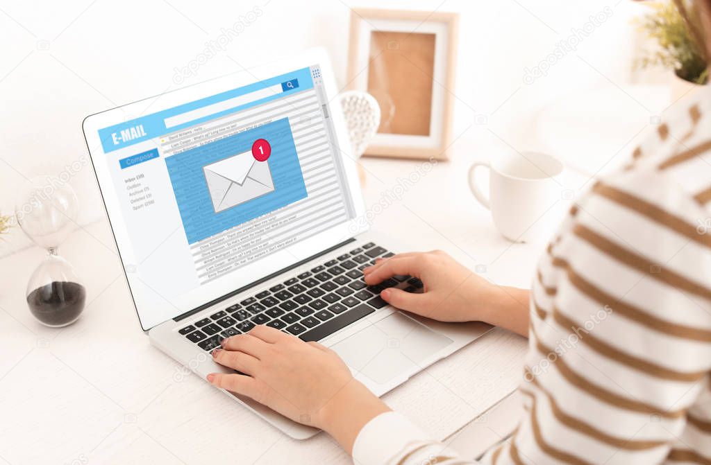 Young woman with laptop checking an email at home