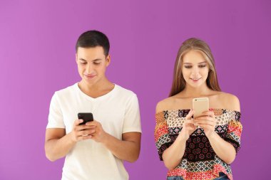 Cep telefonlarıyla renk arka plan üzerinde genç çift