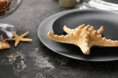 Koyu arka plan üzerinde deniz yıldızı ile güzel sofra