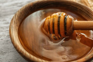 Tatlı bal, kepçe ve ahşap masa, closeup buğday ile kase