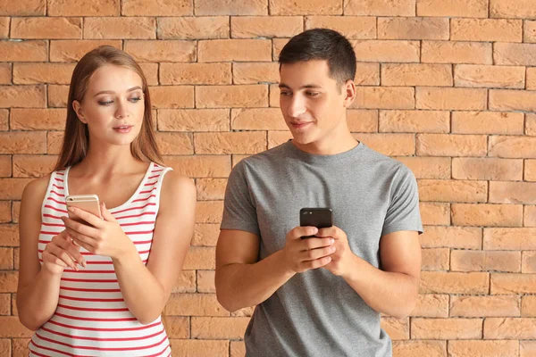 Young Couple Mobile Phones Brick Wall — Stock Photo, Image