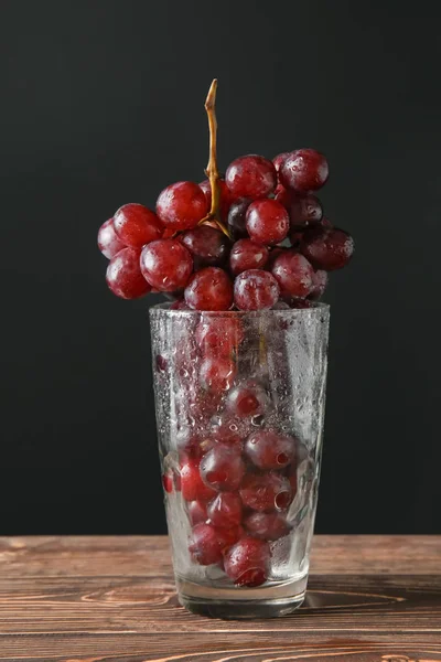 Glas Met Druiven Tafel Tegen Donkere Achtergrond — Stockfoto