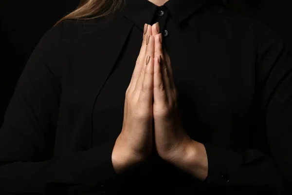 Hands of young praying woman, closeup