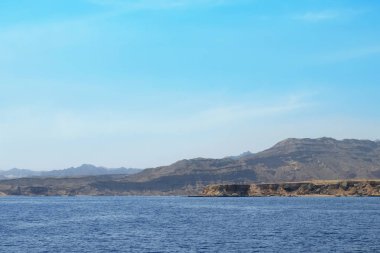 Deniz ve dağlarla dolu güzel bir manzara.