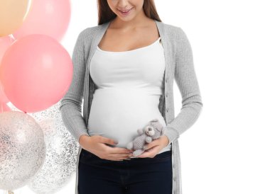 Beyaz arka plan üzerinde oyuncak ve hava balonlu güzel hamile kadın