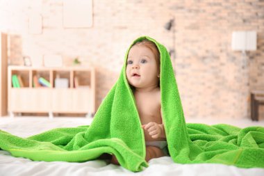 Evde yatakta yumuşak havlu ile şirin bebek