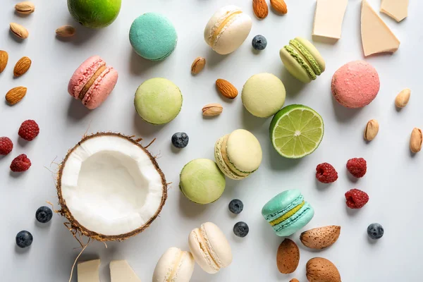 Scattered Tasty Macaroons Coconut Berries Nuts White Table — Stock Photo, Image
