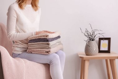 Kadın kanepe evde temiz yumuşak havlu yığını ile