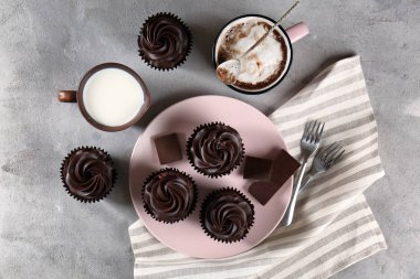 Lezzetli çikolata cupcakes, bardak kahve ve süt gri tablo ile kompozisyon