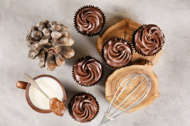 Süt gri masada fincan ile lezzetli çikolata cupcakes