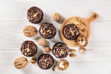 Çikolata cupcakes ve ceviz ahşap masa üzerinde kompozisyonu