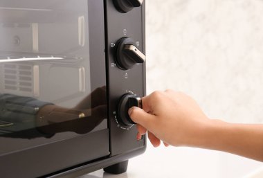 Kadın mutfakta elektrikli fırın ayarlama